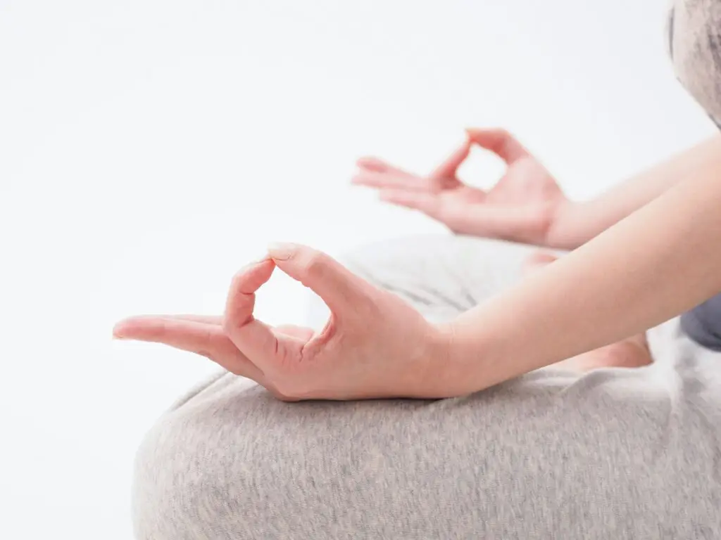 Japanese woman meditating on white background